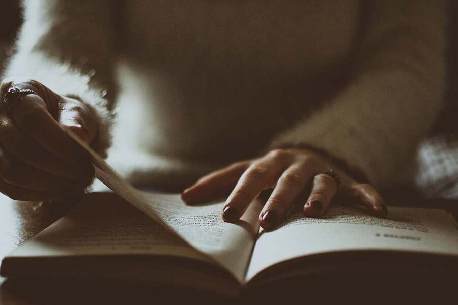Dark image of hands flipping through a book