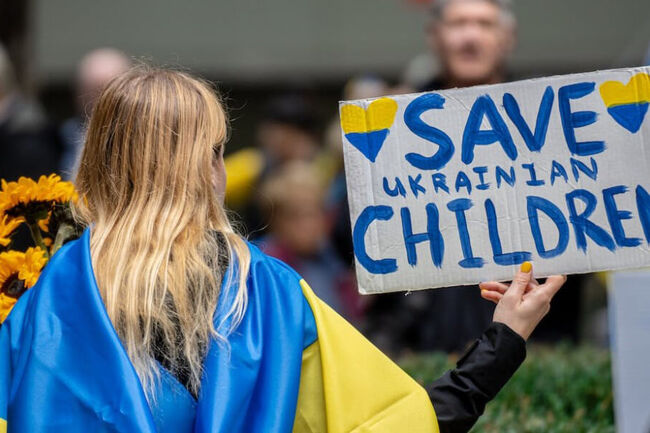 Ukranian woman with sign saying "save Ukranian children"