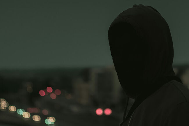Figure looking at the city in the dark