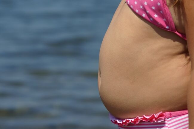 Close-up of a child in a bikini with a chubby belly