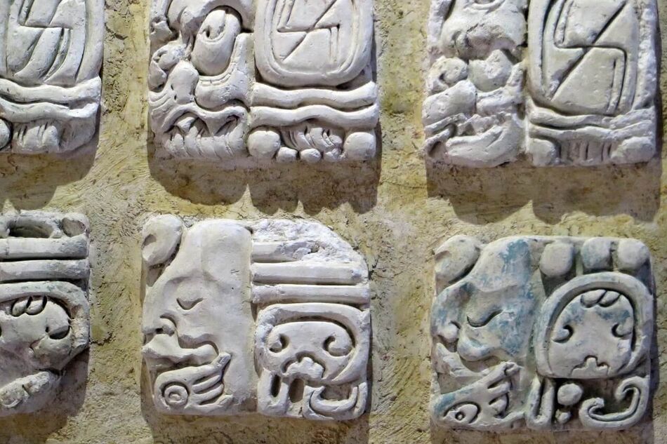 Billedet viser Maya-hieroglyffer, som er et komplekst skriftsystem udviklet af Maya-civilisationen i Mesoamerika.