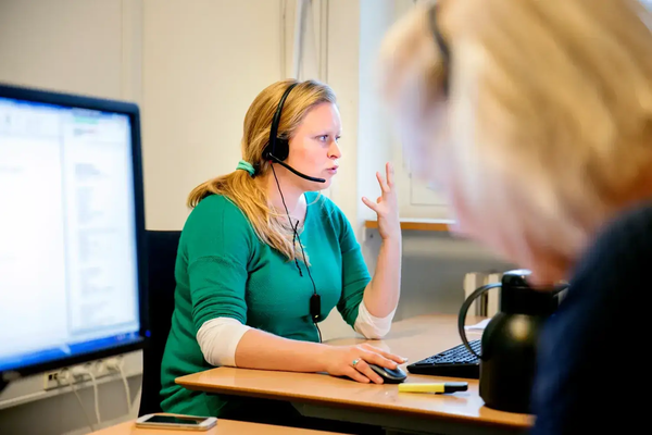 En studievejleder med et headset sidder foran en computer og rådgiver om studievalg på KU